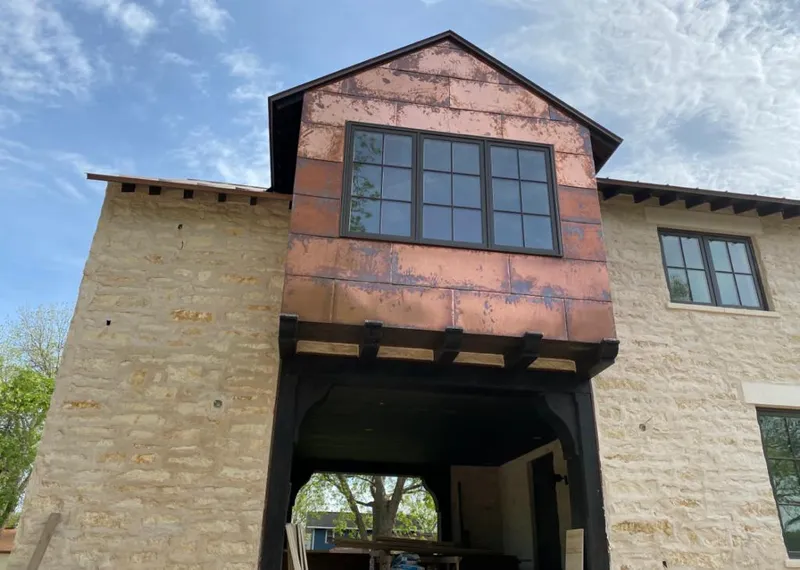 Copper metal panel facade on a stone building for Skylight Installation in Clive