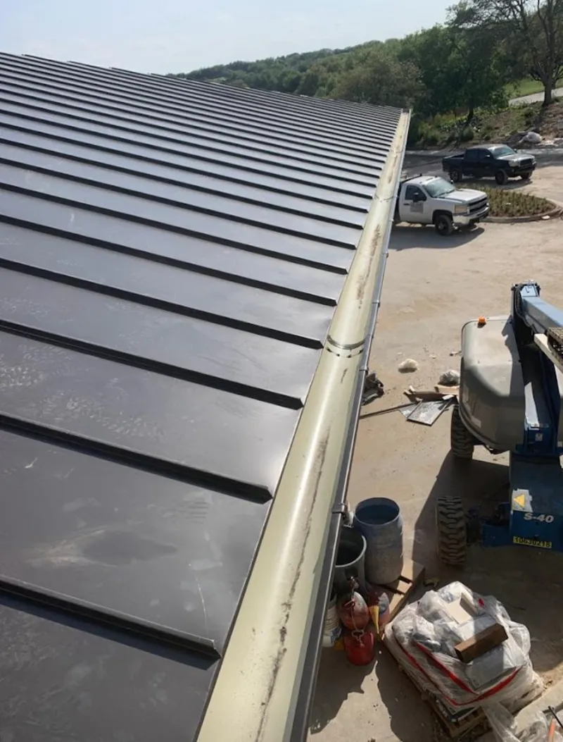 Standing seam panel and gutter detail on a metal roofing jobsite in Clive